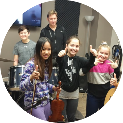 a group of young people in a classroom with instruments and their instructor